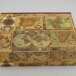Könnte beinhalten: Rechteckige Box, bedeckt mit einer Collage antiker Karten in Beige-, Braun- und Grüntönen. Die Box zeigt eine Windrose und verschiedene kartografische Details. Die Kanten sind mit einem dunkelroten Rand versehen.