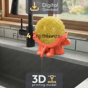May include: An orange 3D-printed sponge holder in the shape of a person, holding a yellow sponge. The holder is placed on the edge of a kitchen sink. The image includes the text "Digital Download" and "3D printing model".