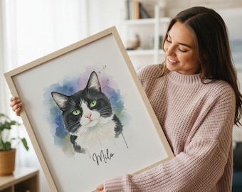 May include: A framed watercolor portrait of a black and white cat with green eyes, named Milo. The artwork features a soft, colorful background with blue and purple hues. The frame is a light wood color.