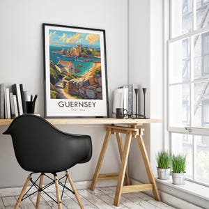 May include: A vintage-style travel poster featuring a colorful illustration of a coastal scene in Guernsey, Channel Islands. The poster has a black frame and is displayed on a desk with a black chair and a wooden easel.