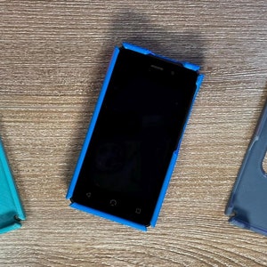 May include: Three phone cases, one blue, one teal, and one gray. The blue case has a black phone inside.