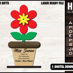 Puede incluir: Un macetero de madera cortado con láser con una flor roja y hojas verdes. El macetero tiene un mensaje personalizado que dice "Miss Saman Gracias por ayudarme a crecer y aprender De: Zoa Haan".