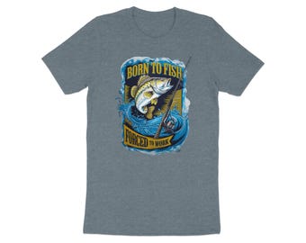 May include: A heather blue t-shirt featuring a graphic of a fish jumping out of water with a fishing rod. The text reads "BORN TO FISH FORCED TO WORK" in a blue and gold design.