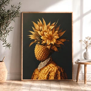 Könnte beinhalten: Gerahmter Kunstdruck mit einem Ananaskopf, der mit goldenen Blumen und Blättern geschmückt ist. Die Figur trägt eine goldfarbene Jacke mit Muster und einem weißen Spitzenkragen vor dunklem Hintergrund. Das Kunstwerk wird in einem Raum mit Holzboden ausgestellt.
