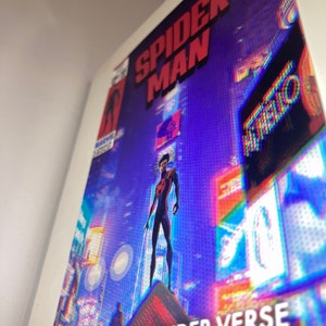 Puede incluir: Una portada de c&oacute;mic con Spider-Man de pie en un edificio en un horizonte urbano. La portada es de un azul vibrante con acentos rojos y amarillos. El texto en la portada dice "Spider-Man" y "Across the Spider-Verse".