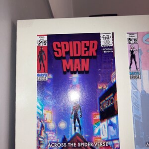 Puede incluir: Una portada de c&oacute;mic con Spider-Man de pie en un edificio en un horizonte urbano. La portada es azul y morada con un efecto glitch. El texto en la portada dice "Spider-Man" y "Across the Spider-Verse".