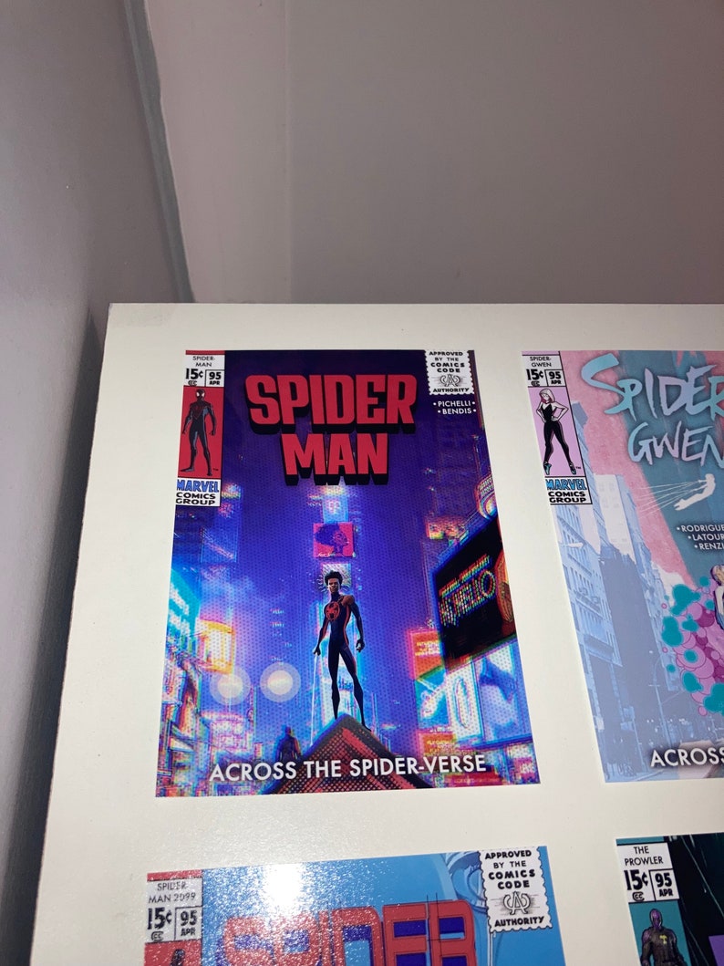 Puede incluir: Una portada de c&oacute;mic con Spider-Man en un traje negro y rojo de pie en un edificio en un horizonte urbano. La portada se titula "Spider-Man: Across the Spider-Verse".