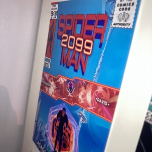 Pu&ograve; includere: Una copertina di fumetto incorniciata per "Spider-Man 2099" con uno sfondo blu e testo rosso e arancione. La copertina include il logo Marvel Comics Group, il sigillo Comics Code Authority e il testo "Across the Spider-Verse".