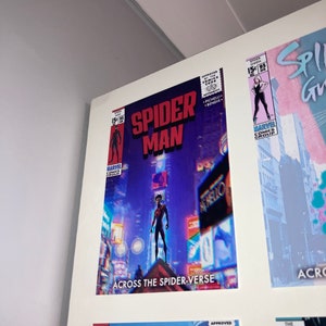 Puede incluir: Una portada de c&oacute;mic con Spider-Man con un traje negro de pie en un edificio con una ciudad en el fondo. La portada se titula "Spider-Man: Across the Spider-Verse".