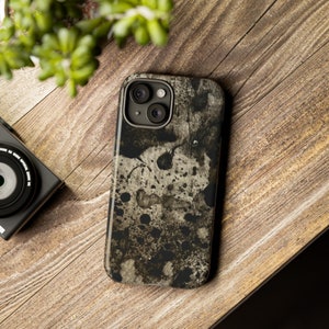 Könnte beinhalten: Eine abstrakte Handyhülle in Schwarzweiß mit einem Sprühfarben-Design. Die Hülle hat eine erhöhte Kamerabuckel mit zwei Linsen.