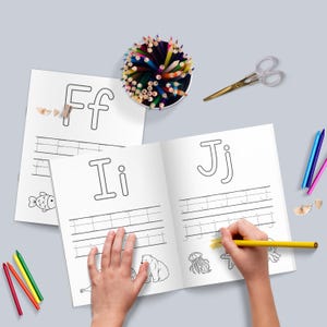May include: A black and white workbook with pages for practicing writing the letters F, I, and J. The workbook has dotted lines to help guide the child's hand. The pages also feature illustrations of a fish, a polar bear, a jellyfish, and an octopus.