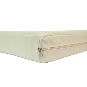 May include: A cream-coloured rectangular dog bed with a zipper closure.