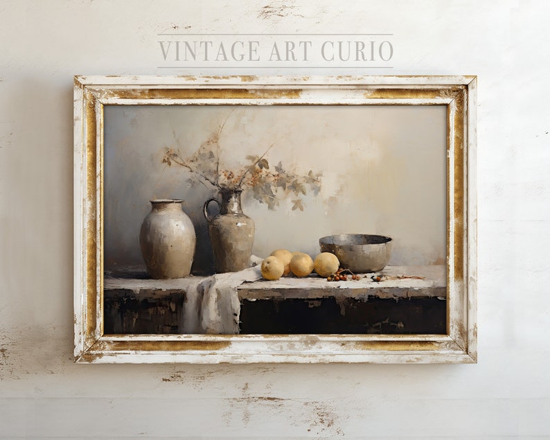 May include: A still life painting in a white frame with gold accents. The painting depicts a bowl, two ceramic jars, and a bowl of fruit on a wooden table. The background is a muted gray with a sprig of berries and leaves.