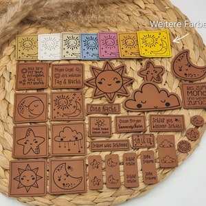 Könnte beinhalten: Eine Sammlung brauner Lederpatches mit verschiedenen Designs, darunter Sterne, Monde, Sonnen, Wolken und Text. Der Text enthält Sätze wie "You are my sun", "Cute Nacht", "Schlaf gut kleiner Schatz" und "Bis zum Mond".