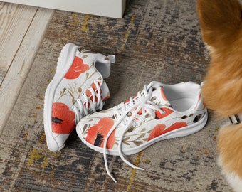 Può includere: Un paio di scarpe da ginnastica bianche con una stampa floreale con papaveri rossi. Le scarpe hanno lacci bianchi e una suola bianca.