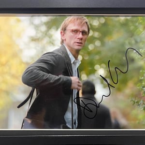 ダニエル・クレイグ、007 ジェームズ・ボンド俳優、AFTAL COA 付き直筆サイン入り宣伝写真 - 黒額入り 12' x 9' インチ