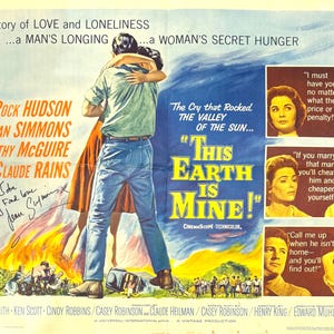 Op de afbeelding: Een vintage filmposter voor de film "This Earth Is Mine!" met Rock Hudson, Jean Simmons, Dorothy McGuire en Claude Rains. De poster toont een stel dat elkaar omhelst op de voorgrond, met een vurige achtergrond en tekst die "The Cry that Rocked The Valley of the Sun..." en "This Earth Is Mine!" luidt.