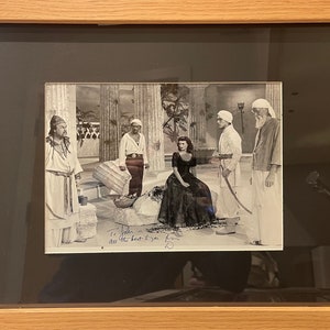 Peut inclure: Photographie en noir et blanc d'une scène de film, mettant en scène une femme en robe longue et quatre hommes en costumes traditionnels. La femme a signé la photo "To John, all the best to you & yours, Hedy Lamarr".