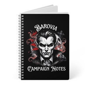 May include: A black spiral notebook with a white spine. The cover features a black and white illustration of a vampire with the text "Barovia Campaign Notes".