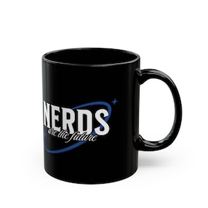 Könnte beinhalten: Schwarze Keramik-Kaffeetasse mit einer weißen und blauen Grafik, auf der "NERDS are the future" steht.
