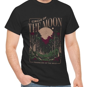 May include: Black t-shirt with a vintage-style graphic of a moon and forest scene. The text "Circle of the Moon - Guardians of the Wild" is printed on the shirt.