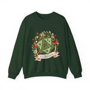 May include: A dark green sweatshirt featuring a green and white twenty-sided die surrounded by a wreath of leaves, flowers, and mushrooms. The die shows the numbers 2, 8, 14, and 20. A white ribbon with the text "All Natural" is beneath the die.