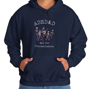 Puede incluir: Sudadera con capucha azul marino con un gráfico blanco de un esqueleto tocando un laúd con el texto "ADHD&D Roll For Procrastination".