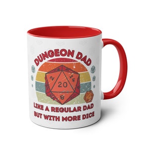 May include: White ceramic mug with a red rim and handle. The mug features a retro-style design with a 20-sided die and the text "Dungeon Dad Like a Regular Dad But With More Dice".