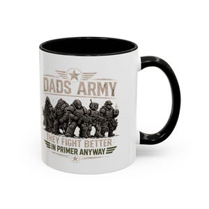 May include: White ceramic mug with a black interior and handle. The mug features the text "DADS ARMY" above an illustration of a group of soldiers. Below the illustration is the text "THEY FIGHT BETTER IN PRIMER ANYWAY".