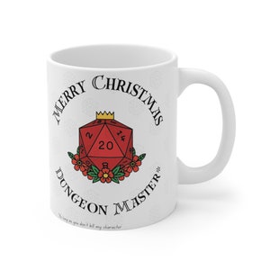 Może przedstawiać: Biały ceramiczny kubek z uchwytem. Posiada czerwony dwudziestościenny wzór kości, złotą koronę i napis "MERRY CHRISTMAS DUNGEON MASTER". Wzór otoczony jest czerwonymi kwiatami i tekstem "As long as you don't kill my character".