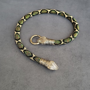 Grönt pärlhalsband med orm, mässingsdetalj