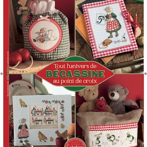 Peut inclure: Une couverture de livre avec un motif à carreaux rouge et blanc et le titre "Tout l'univers de Bécassine au point de croix". La couverture présente également des illustrations d'une fille en robe rouge et blanche, d'un ours en peluche et d'un sac à carreaux rouge et blanc.