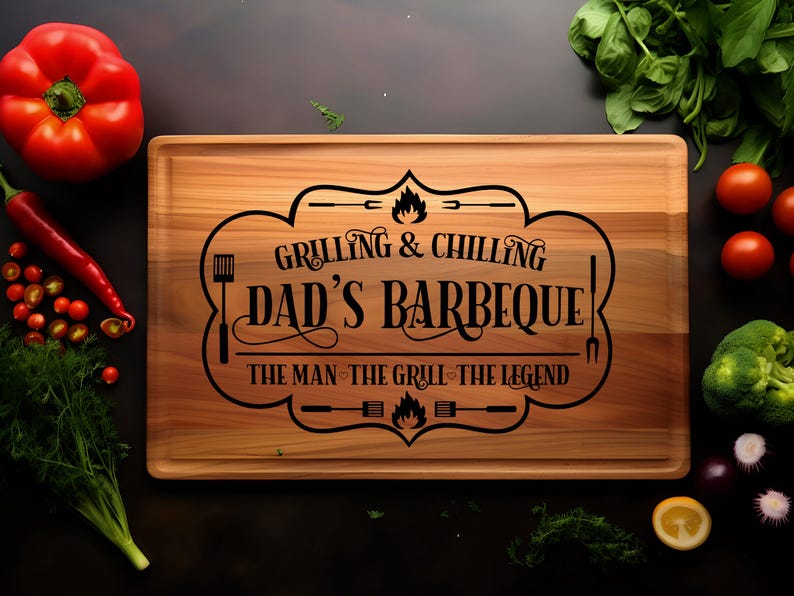 May include: A wooden cutting board with the text "Grilling & Chilling Dad's Barbeque! The Man - The Grill - The Legend" engraved on it. The board is surrounded by various vegetables and herbs.