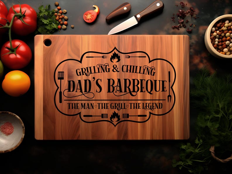 May include: A wooden cutting board with the text "Grilling & Chilling Dad's Barbeque! The Man, The Grill, The Legend" engraved on it.