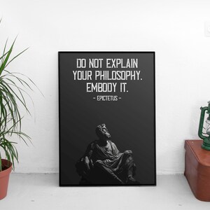 Puede incluir: Impresi&oacute;n en blanco y negro con una cita de Epicteto: "No expliques tu filosof&iacute;a. Enc&aacute;rnala." La cita est&aacute; centrada en un fondo negro con una imagen en blanco y negro de un hombre sentado en una silla.