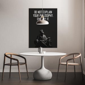 Puede incluir: Un p&oacute;ster en blanco y negro con una cita que dice "No expliques tu filosof&iacute;a. Enc&aacute;rnala." El p&oacute;ster presenta una imagen en blanco y negro de una persona sentada en un trono.