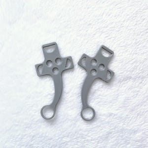 May include: Two grey plastic gaming controller-shaped keyrings with a loop at the bottom.