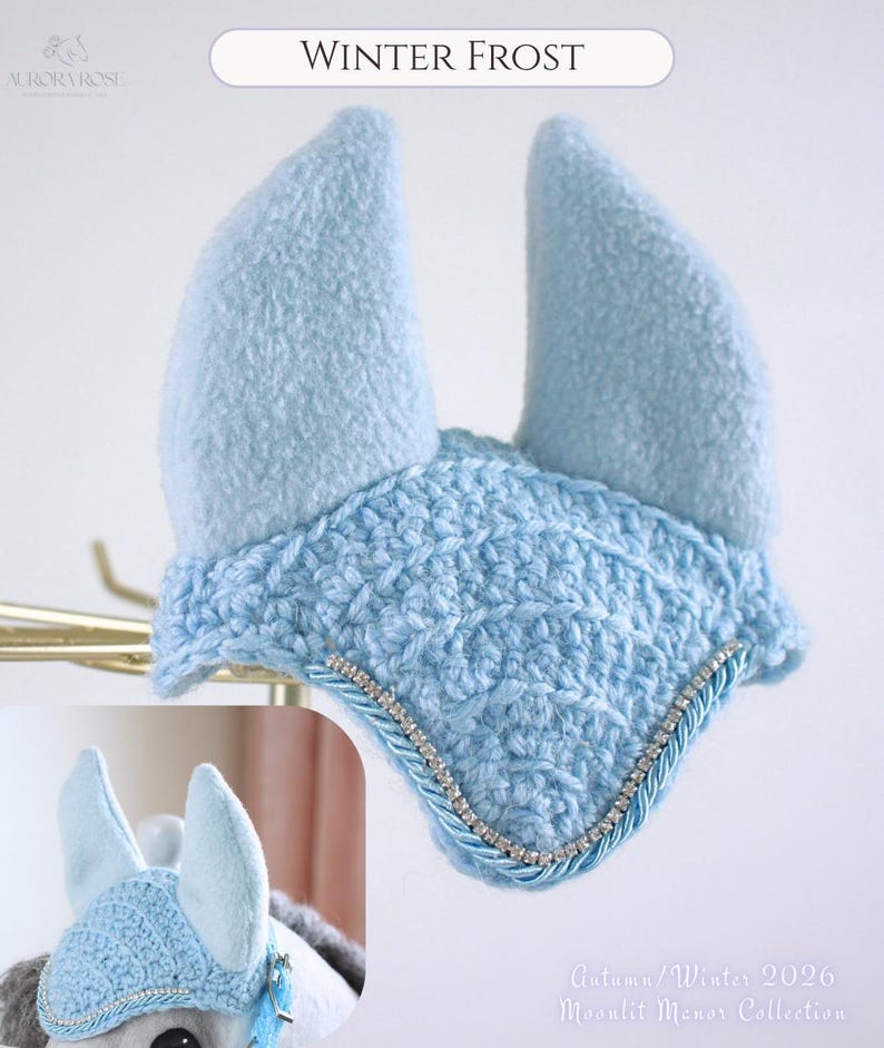 May include: A light blue horse ear bonnet featuring a textured crochet front panel, two soft fleece ear covers, and a decorative trim consisting of a silver rhinestone chain bordered by twisted light blue cord. The text reads Winter Frost.