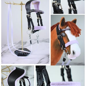 May include: A black horse bridle with lavender padding and a browband featuring rows of purple crystals. The set includes silver-toned metal hardware, buckles, and a lavender lead rope. The text Autumn/Winter 2026 Moonlit Manor Collection and Lavender Mist is visible.