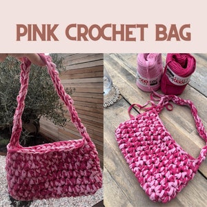 Op de afbeelding: Roze gehaakte tas met een gevlochten band. De tas is gemaakt van roze en lichtroze garen. De tekst "PINK CROCHET BAG" staat bovenaan de afbeelding.