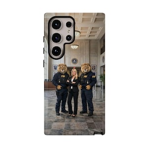 May include: A phone case featuring a humorous image of three people in an FBI setting. Two figures are dressed as lions in FBI uniforms, flanking a woman in a black suit. The background shows a building interior.
