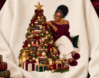 May include: A cream-colored crewneck sweatshirt featuring a graphic print of a person with dark hair wearing a maroon off-the-shoulder top and white pants, sitting beside a Christmas tree constructed from stacked books, ornaments, and lights.