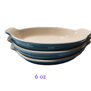 以下が含まれることがあります： 白の内側を持つターコイズブルーの3つの積み重ねられた楕円形のセラミックベーキングディッシュ。ディッシュは両側に2つのハンドルが付いています。ディッシュはそれぞれ6オンスです。