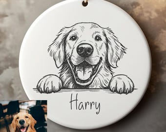 May include: White ceramic ornament with a black and white illustration of a Golden Retriever dog. The dog is smiling with its tongue out, and the name "Harry" is written below. A brown string is attached for hanging.