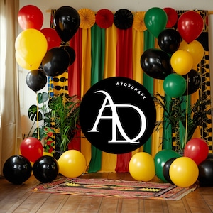 May include: A black and white circle with the letters "AD" in white, surrounded by black, yellow, red, and green balloons. The background is a striped curtain with red, yellow, green, and black stripes. The text "ATDSCRAFT" is written in white above the letters "AD".