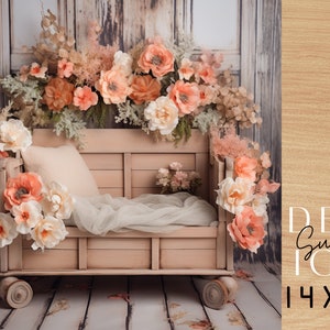 May include: A light pink wooden crib with wheels, decorated with a floral garland of peach and white flowers. The crib is set against a rustic wooden backdrop.