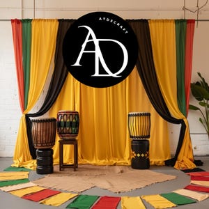 May include: Three djembe drums with different designs and colors are set up on stands in front of a backdrop of yellow, black, green, and red fabric curtains. The curtains are draped in a way that creates a stage-like setting. A black circle with the text "ATDSCRAFT" and the letters "AD" in white is centered on the backdrop.