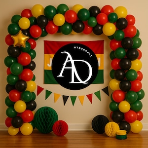 May include: A festive party decoration featuring a balloon arch in red, green, yellow, and black. A gold star balloon and a banner with matching colors are included. The backdrop includes a flag and the text "ATDSCRAFT".