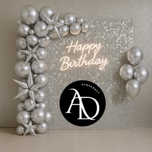 以下が含まれることがあります： シルバーのバルーンアーチと星型の装飾が、「Happy Birthday」のネオン文字をあしらった背景を縁取っています。シルバーのバルーンの束と、白い文字の黒いロゴが、お祝いのシーンを完成させています。
