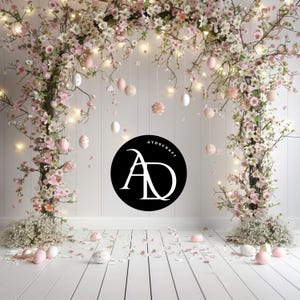 May include: A white wooden floor with pink flower branches and white lights hanging from the ceiling. There are pink and white Easter eggs scattered on the floor. A black circle with the text "ATDSCRAFT" and the letters "AD" in white is on the wall.